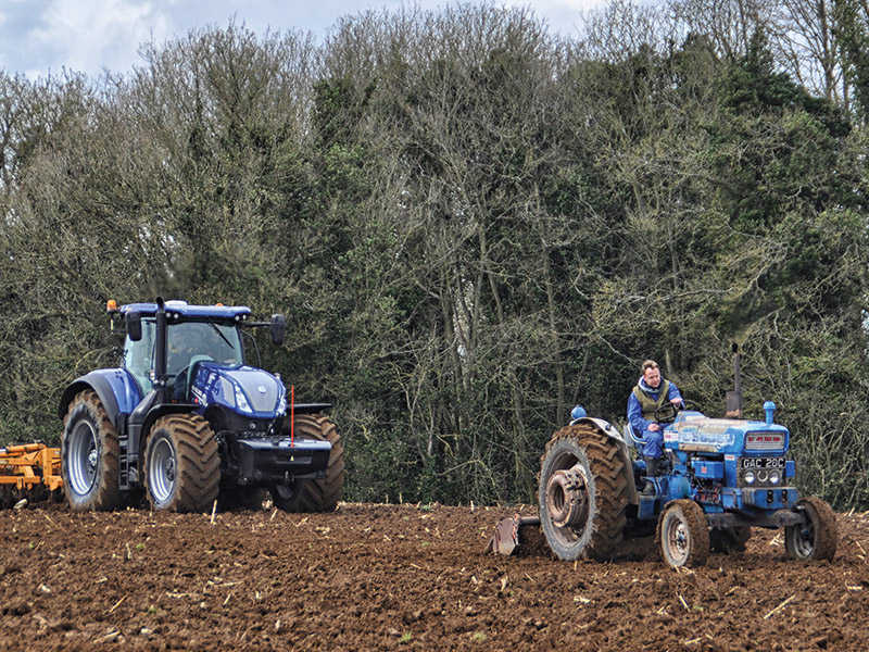 old and new tractor in field