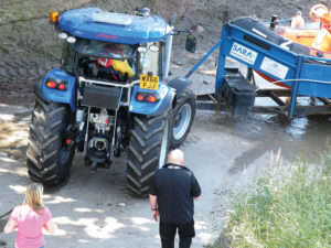 tractor pulling trailer out of river