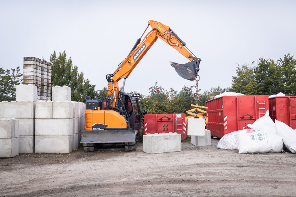 Doosan DX140LCR-7 Reduced Tail Swing Excavator picking up concrete block